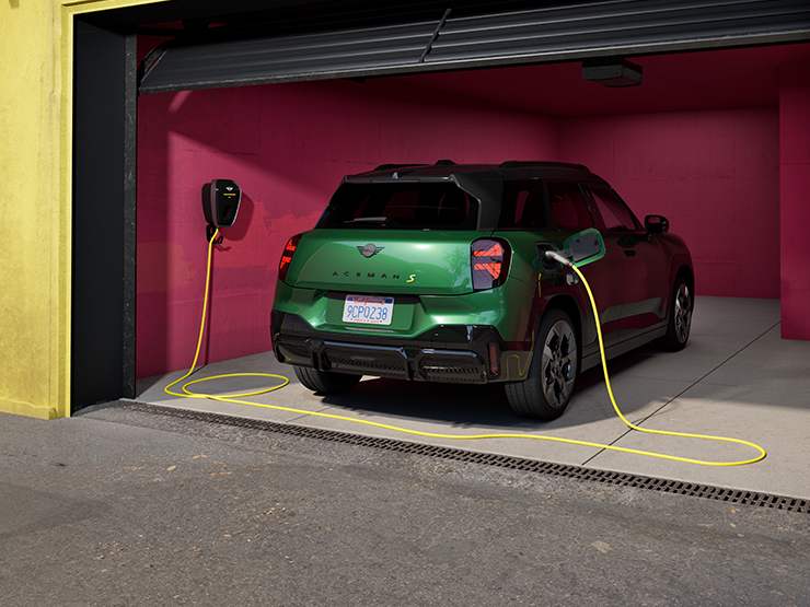 MINI Aceman in British Racing Green IV Metallic charging inside a garage using a wall-mounted charger.