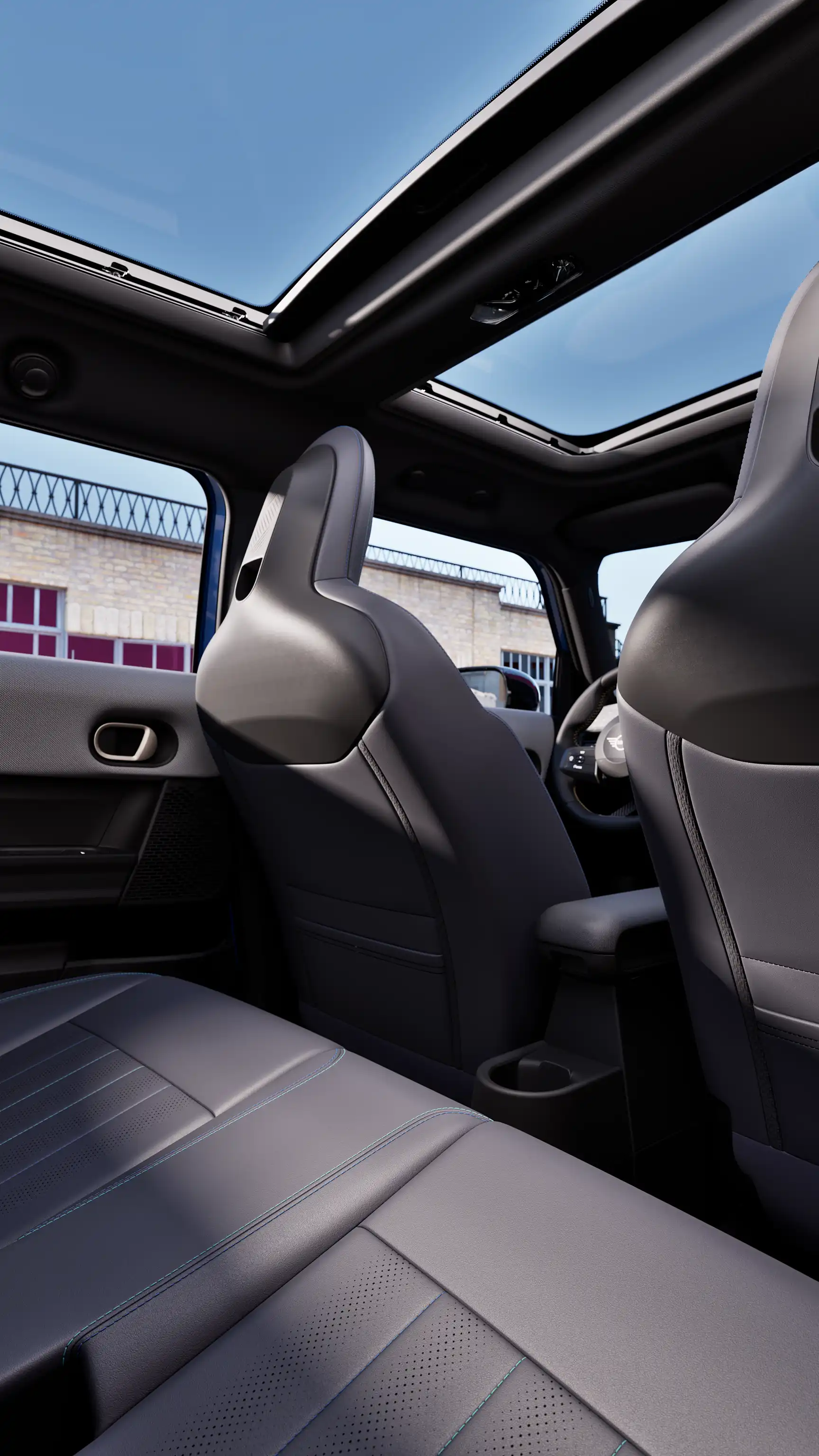 View of the MINI interior from the rear seats, featuring panoramic sunroof and front cabin design.