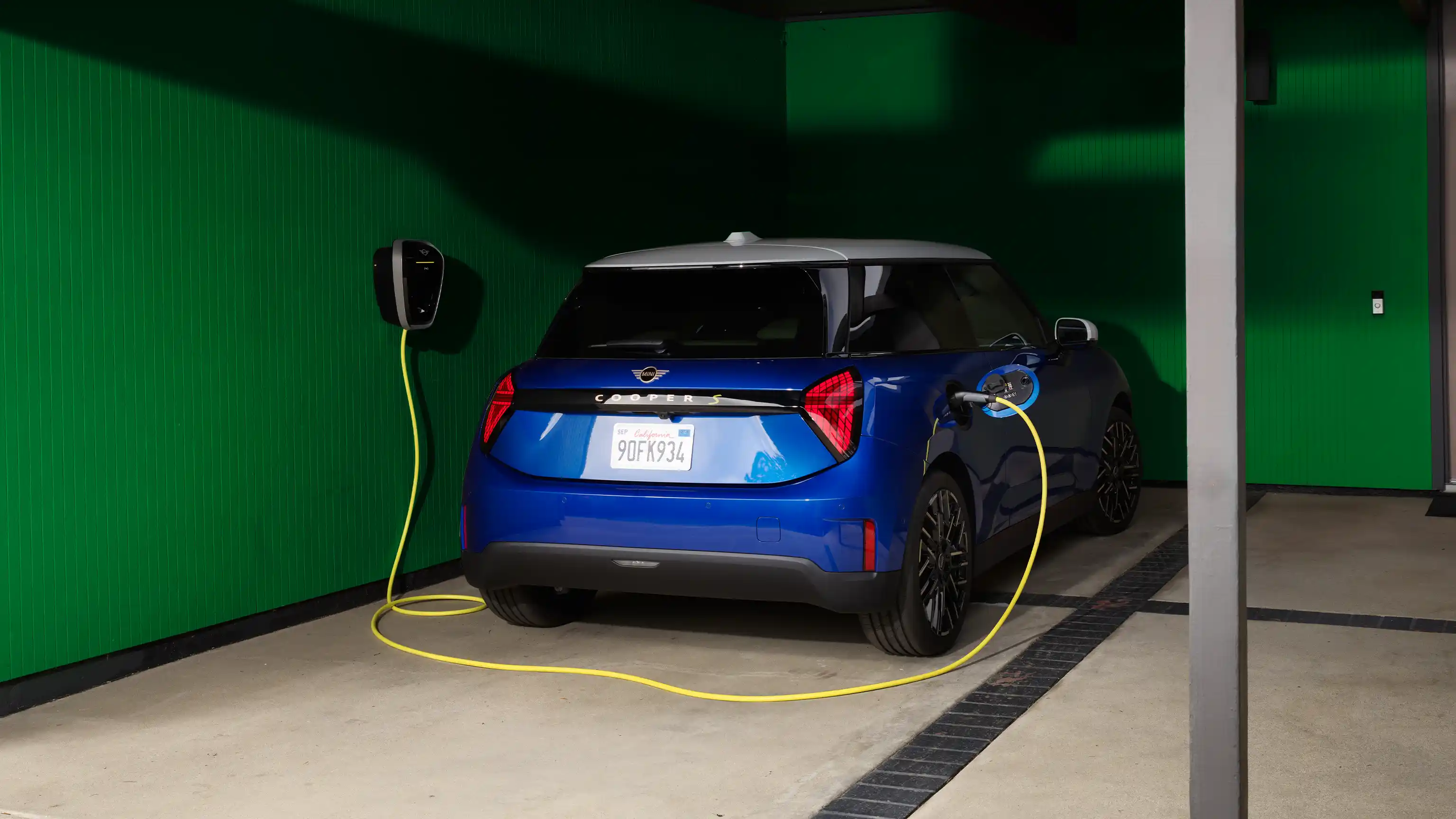 MINI Cooper in Blazing Blue Metallic parked in a covered space while charging.